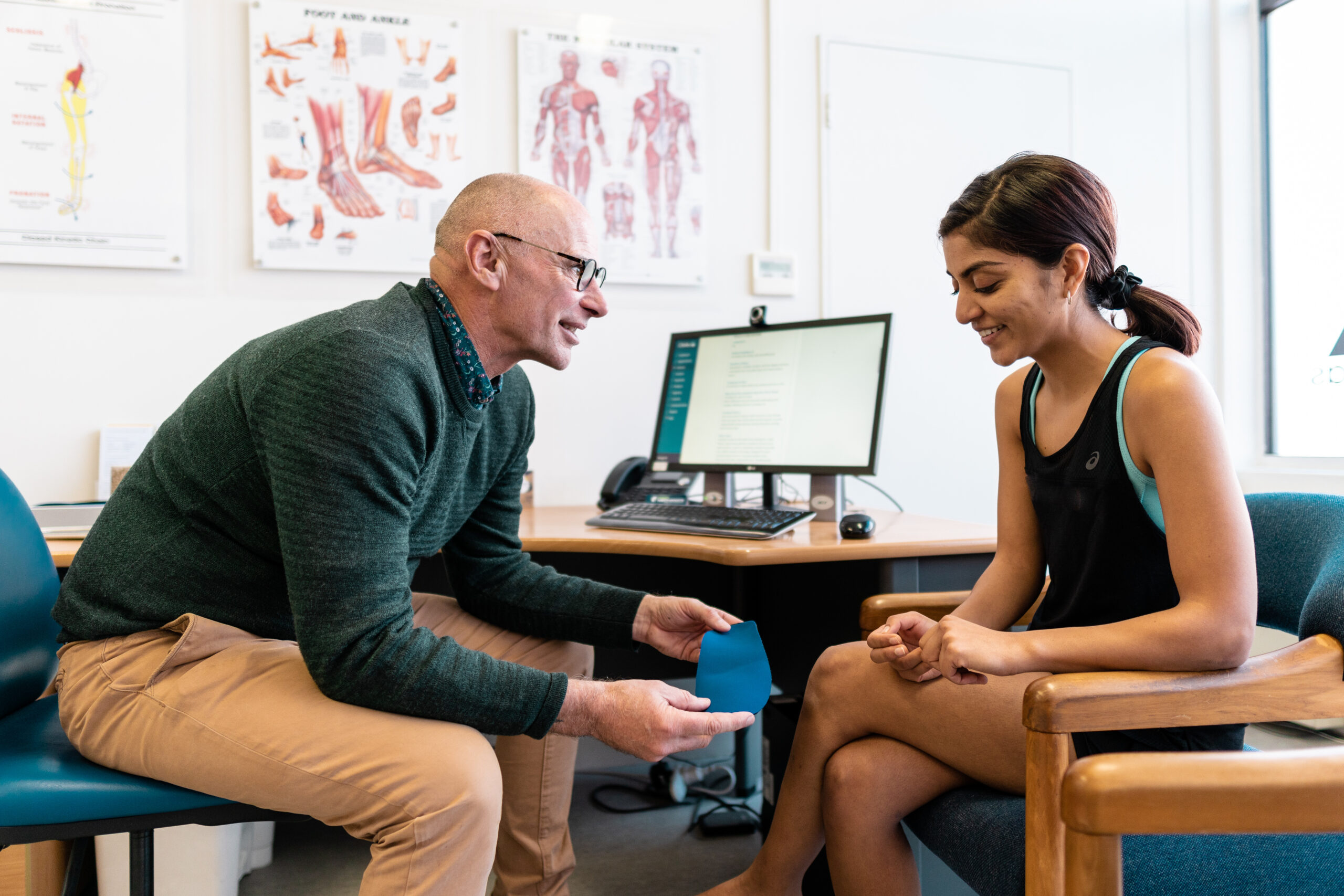 James Baxter conducting a Lower Limb Musculoskeletal Assessment - showing patient a pair of orthotics